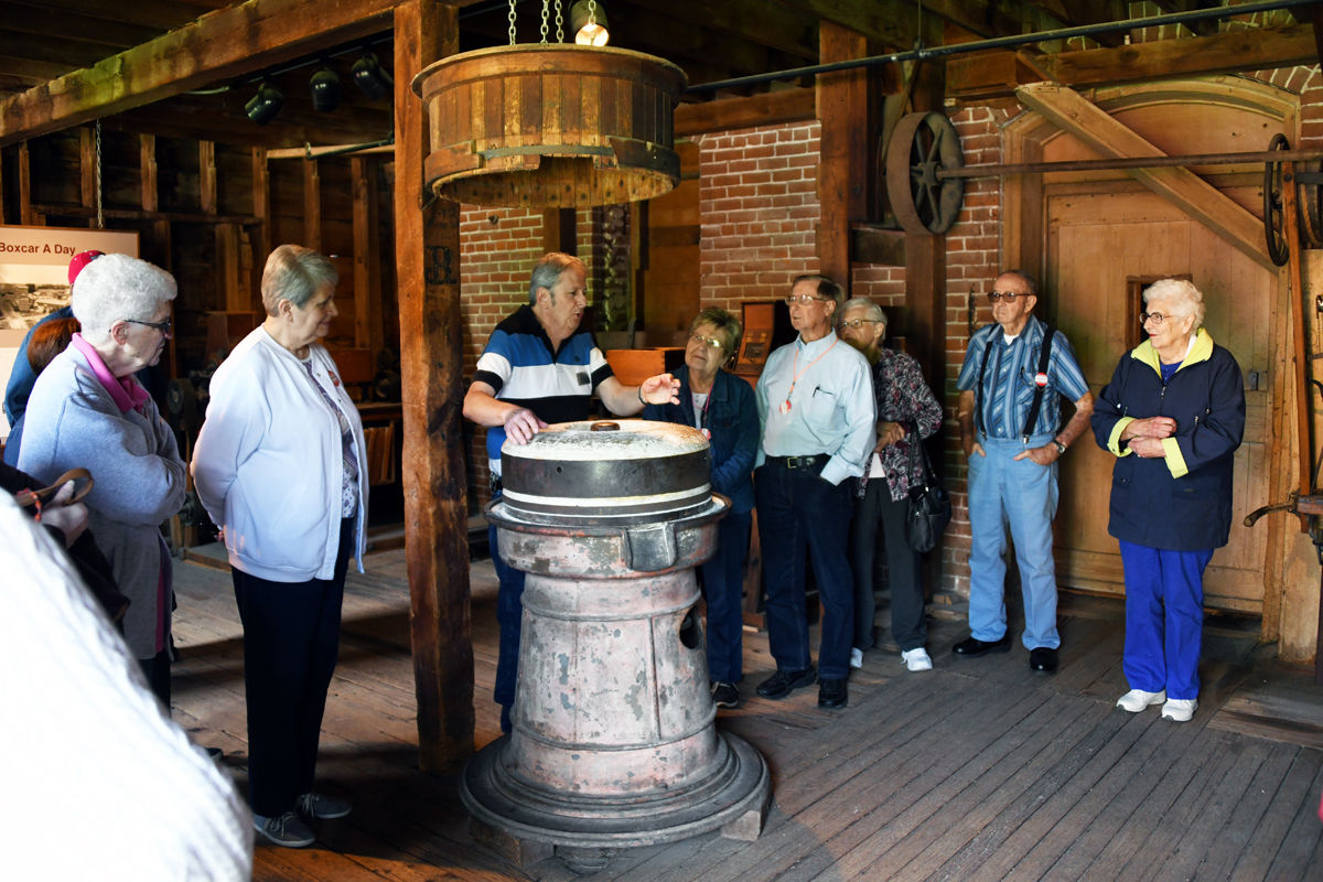 005 Tour guide at the flour mill demonstrated the old way of grinding flour with a stone.JPG